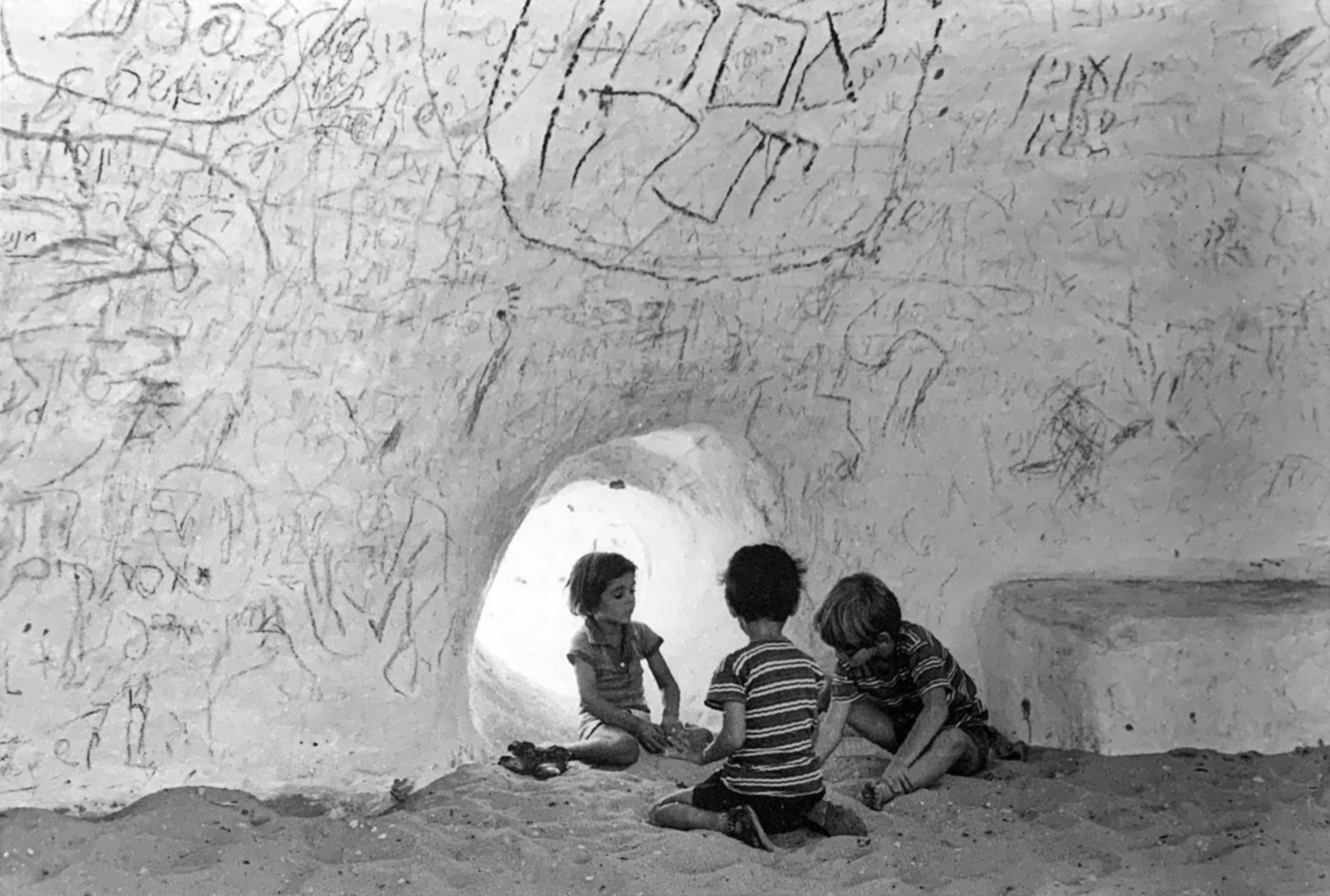 children playing on the inside of the Golem sculpture in the sand